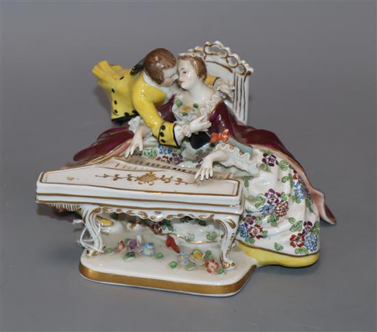 A Sitzendorf porcelain group of amorous lovers seated at a spinet height 11cm